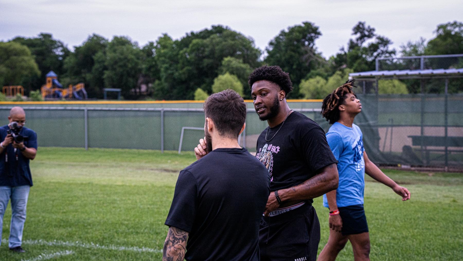 Cameron Goodson talking with an athlete on the field